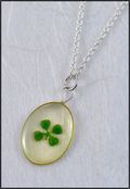 Silver Trimmed Oval Mirage Necklace with Four Leaf Clover